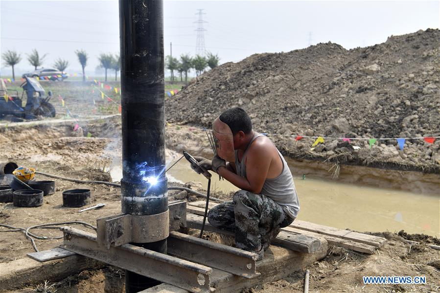 An expert welds a pipe at Dawang Township of Anxin County, north China's Hebei Province, July 1, 2017. The geological survey has started in Xiongan New Area, a new economic zone near Beijing. (Xinhua/Jin Liangkuai)