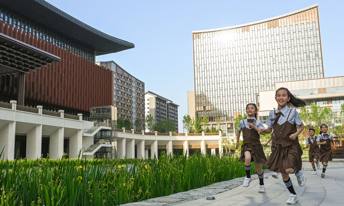 Children run in front of the business and service convention center in Xiong
